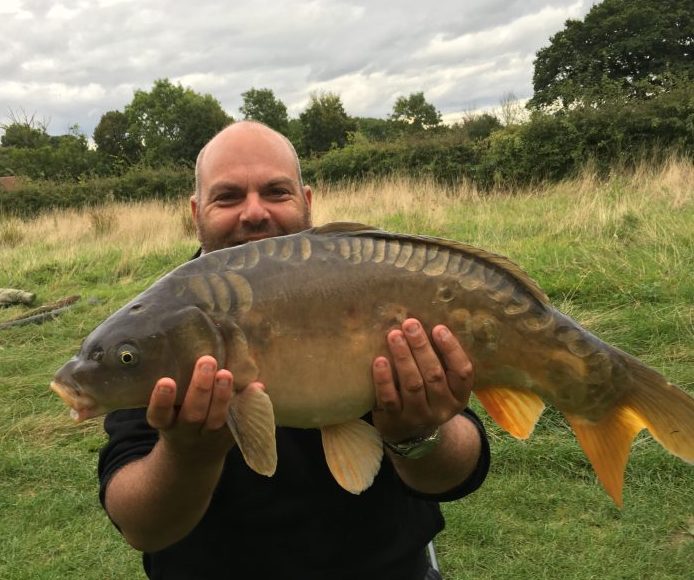 A photo of Ian Barber with a monster carp.